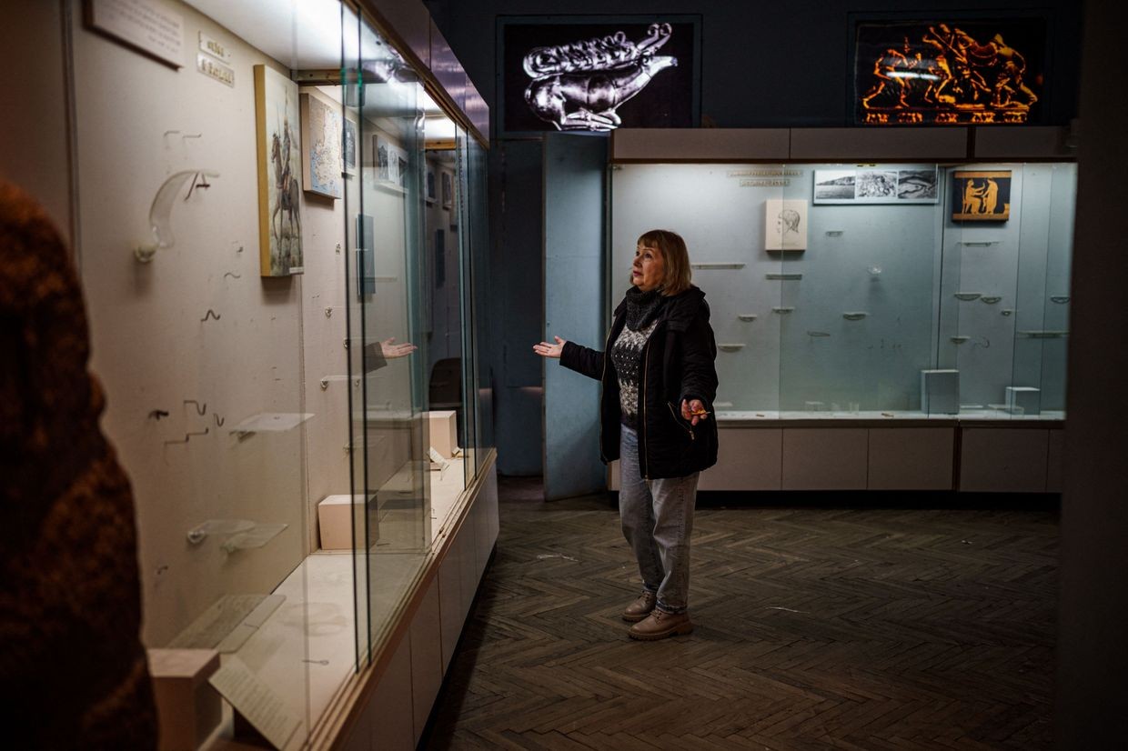 Interim director stands by looted display cases at Kherson museum during Russia’s full-scale war, on Dec. 20, 2022.