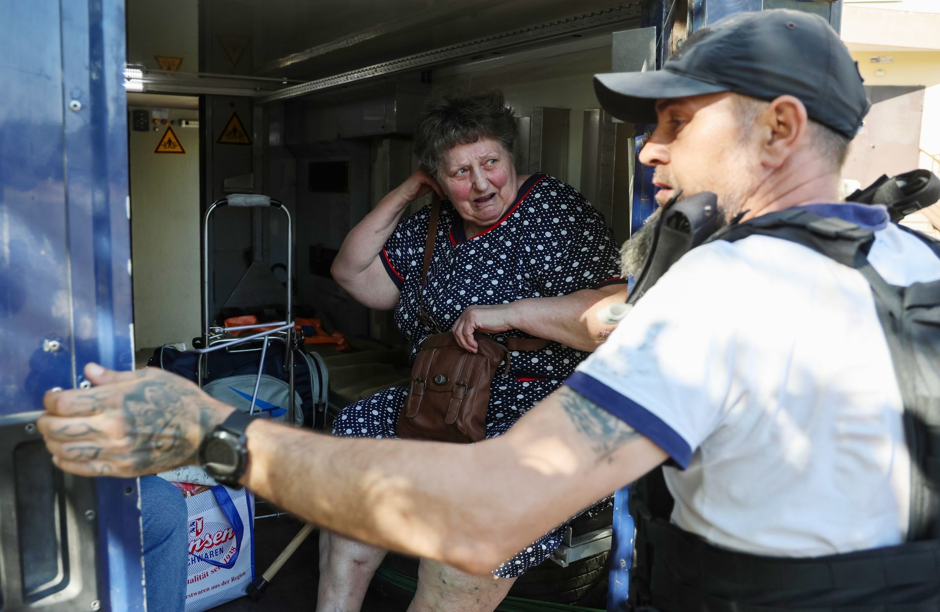 Volunteers help local residents evacuate in Kherson, Ukraine, on Aug. 4, 2025.
